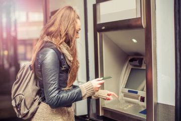 Young woman uses an ATM