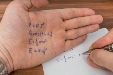 A student in an exam copies from things written on their hand A student in an exam copies from things written on their hand
