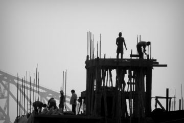 Construction workers and Engineers working for the construction of a high rise building in Kolkata with the famous Howrah Bridge in the background. Construction workers and Engineers working for the construction of a high rise building in Kolkata with the famous Howrah Bridge in the background.