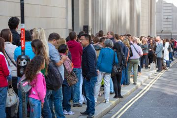 A long queue of people in a street A long queue of people in a street