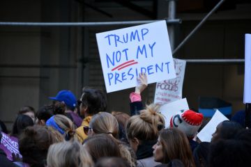 Someone in a crowd holds up a sign saying 'Trump - not my president' Someone in a crowd holds up a sign saying 'Trump - not my president'