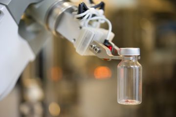 Robot hand picks up glass bottle in lab Robot hand picks up glass bottle in lab