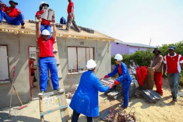 Community members building a low cost house as a team in Soweto.