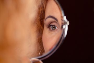 istock self-scrutiny A woman's eye reflected in a mirror