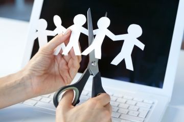 Someone cuts some human figures out of paper Someone cuts some human figures out of paper