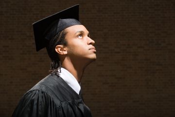 Black graduate looking up