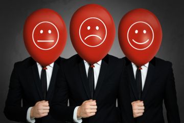 Men holding balloons which show different facial expressions Men holding balloons which show different facial expressions