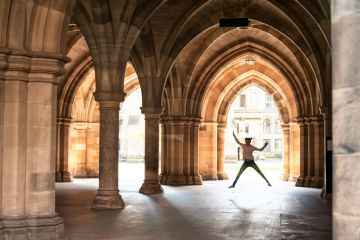 Girl jumping in cloisters of University of Glasgow
