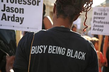 An attendee, wearing a T-shirt stating “busy being black”, holds a placard during a vigil for former Cambridge professor Jason Arday in Trafalgar Square on 17 August 2026 in London, United Kingdom. An attendee, wearing a T-shirt stating “busy being black”, holds a placard during a vigil for former Cambridge professor Jason Arday in Trafalgar Square on 17 August 2026 in London, United Kingdom.