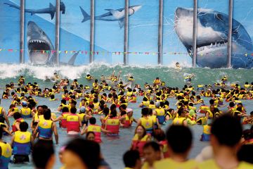 Swimmers in identical life preservers in the sea, face up to giant sharks gnashing at a metal grille Swimmers in identical life preservers in the sea, face up to giant sharks gnashing at a metal grille