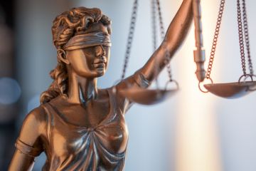 A statue of justice illustrating opinion article about double-blind peer review