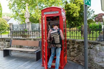 In Germany, a red telephone booth is used for the free exchange of books – a man is looking inside