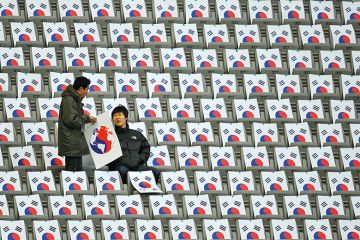 South Koreans sit in seats with the South Korean national flag at the Seoul World Cup Stadium in Seoul South Koreans sit in seats with the South Korean national flag at the Seoul World Cup Stadium in Seoul