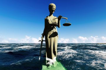 Lady Justice statue sinking into sea water Lady Justice statue sinking into sea water
