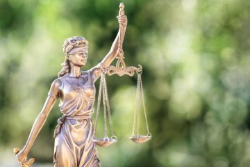 Legal and law concept statue of Lady Justice with scales of justice and green background