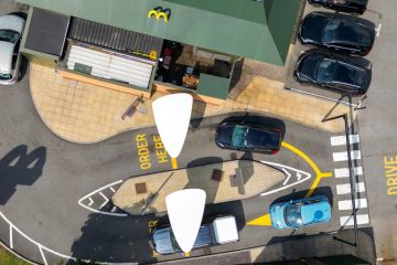Llantrisant, Wales, UK - 19 July 2023 Overhead view of cars in the drive thru entrance of a branch of McDonald's near Talbot Green in south Wales. Llantrisant, Wales, UK - 19 July 2023 Overhead view of cars in the drive thru entrance of a branch of McDonald's near Talbot Green in south Wales.