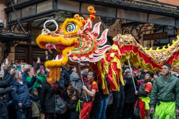 London. UK- 02.11.2024. Close up of a group performing a dragon dance in the Chinese New Year celebration parade with a large appreciative crowd.