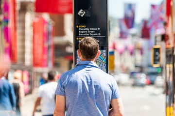 London, UK - June 22, 2018 Back of one man standing reading looking at map for directions to SoHo on Piccadilly sidewalk street road in downtown city