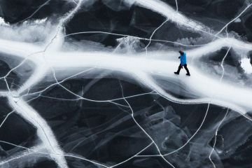 Lone man walking on cracked ice Lone man walking on cracked ice