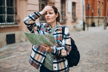 A woman with a map looking lost, sybolising geography department closures