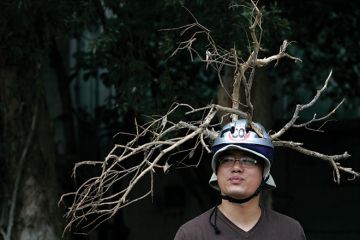 Man wears helmet with branches attached Man wears helmet with branches attached