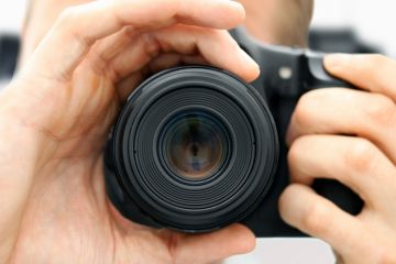 Man focussing camera lens Man focussing camera lens