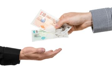 Man handing over British bank notes Man handing over British bank notes