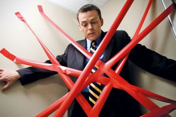 Man held back by red tape Man held back by red tape