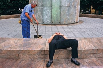 Man lays down while another works behind