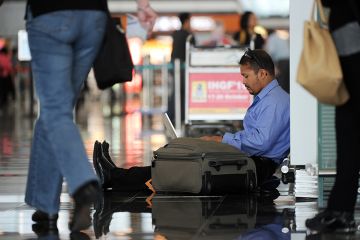 A man uses his laptop while waiting at Hong Kong's international airport, illustrating that many PhD applicants have been left in limbo after a computer glitch affected their application for an Australian visa. A man uses his laptop while waiting at Hong Kong's international airport, illustrating that many PhD applicants have been left in limbo after a computer glitch affected their application for an Australian visa.