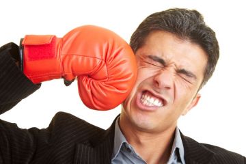 Man punching himself in face with boxing glove Man punching himself in face with boxing glove