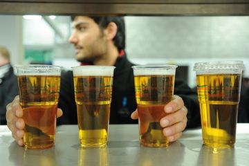 Man reaching for pints of lager Man reaching for pints of lager