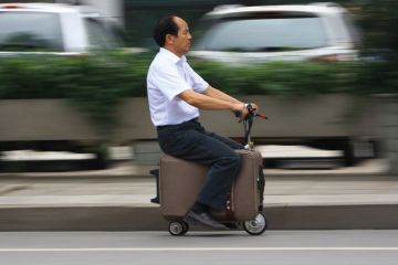 Man rides on electric suitcase Man rides on electric suitcase