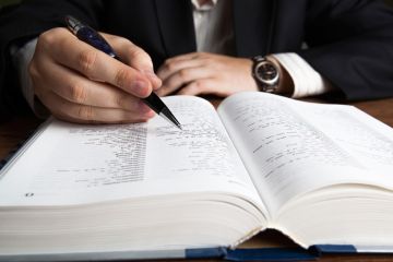 Man scanning dictionary page with pen