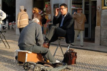 Man shining the shoes of a businessman Man shining the shoes of a businessman