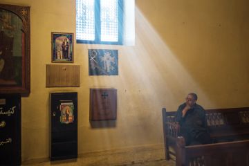Man sitting in sunlight lit church