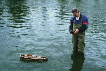 Man using remote-controlled boat