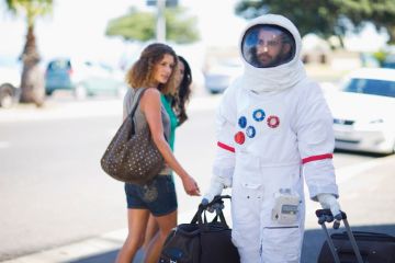 Man walking on street dressed as astronaut