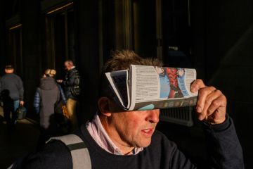 Man is walking with a newspaper in Piccadilly Circus, London