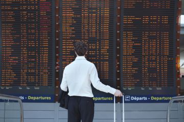 Man looking at airport departure board Man looking at airport departure board