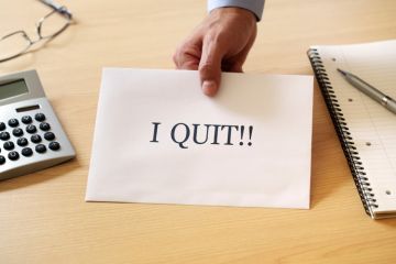 Man's hand holding 'I quit' resignation note Man's hand holding 'I quit' resignation note