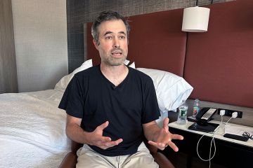Mark Bray, a Rutgers assistant professor of history, waits in a hotel room in Newark, N.J., before a planned flight to Spain on Thursday, 9 October, 2025.