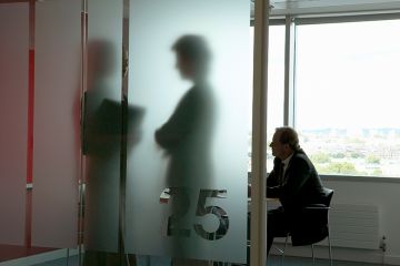 People meeting behind frosted glass. To illustrate companies offering students help in navigating misconduct proceedings operating in a ‘regulatory and ethical grey zone’