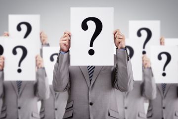 Men in suits holding question marks Men in suits holding question marks