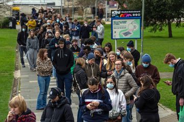 Staff and students, some wearing face masks, queue to receive antibiotics at the University of Kent in Canterbury after an outbreak of meningitis caused the deaths of two people, on 16 March, 2026 in Canterbury, United Kingdom.