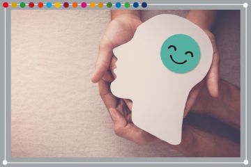Hands holding smiling face in brain paper cutout, to illustrate mental health support.