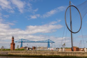 Middlesbrough, England, UK - May 14, 2016 View from the Middlehaven dock towards the transporter bridge, the old clocktower and Temenos