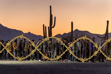 Immigrants line up at a remote U.S. Border Patrol processing centre after crossing the U.S.-Mexico border in Lukeville, Arizona. With added barbed wire twisted in the shape of a DNA helix. To illustrate Donald Trump's divisive misuse of genetics. Immigrants line up at a remote U.S. Border Patrol processing centre after crossing the U.S.-Mexico border in Lukeville, Arizona. With added barbed wire twisted in the shape of a DNA helix. To illustrate Donald Trump's divisive misuse of genetics.