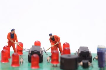 Miniature technicians repair a computer
