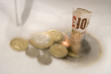 Money washing down the drain, symbolising the diminishing graduate premium